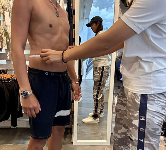 男性がメジャーで腹囲を採寸してもらっている様子