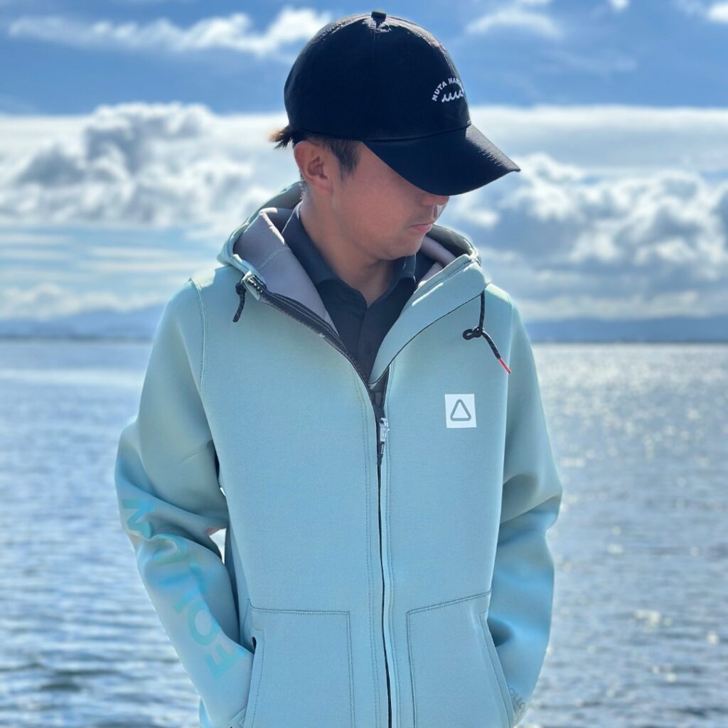 ミント色のボートコートを着た男性